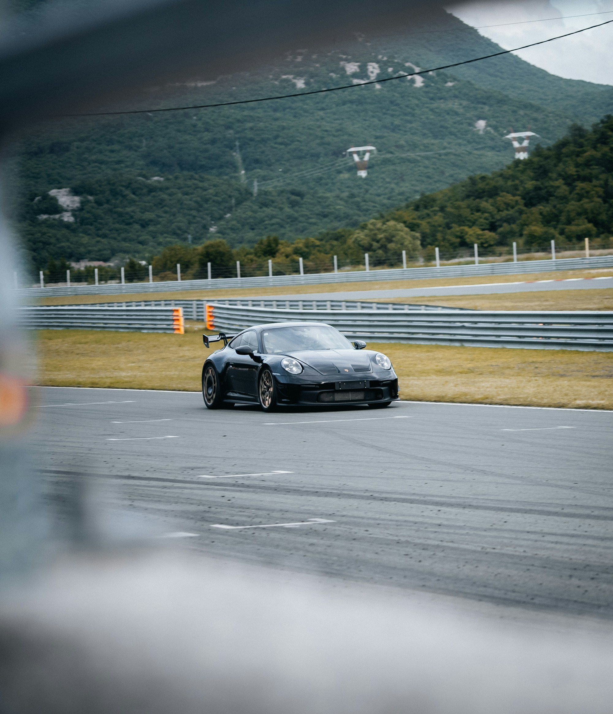 A black sports car taking a corner on a racing circuit